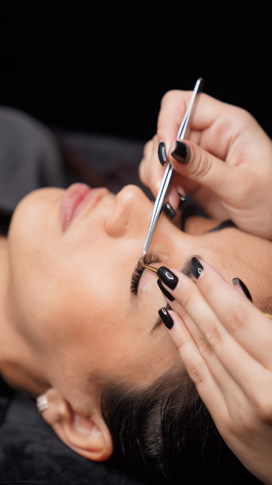 A Person Holding a Tweezer Near the Woman's Eyelashes